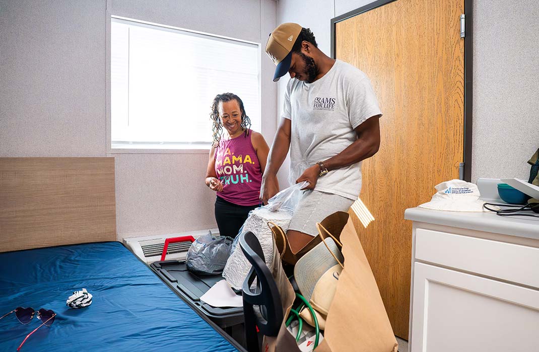 Student in room holding up WCU merch