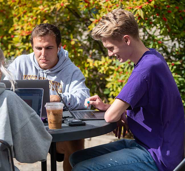 WCU Students sitting outside working on laptop