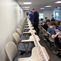 Students in HIS 319 (Medieval Europe) looking at a reproduction of the Bayeux Tapestry for an assignment on the 1066 Normal Conquest of England