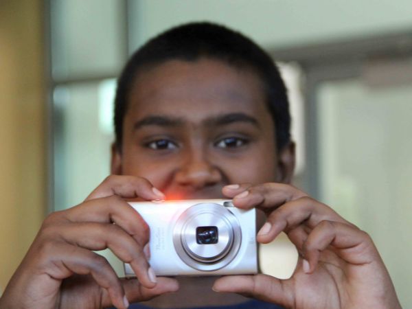 [Student holding a camera in front of his face, preparing to take a photo]