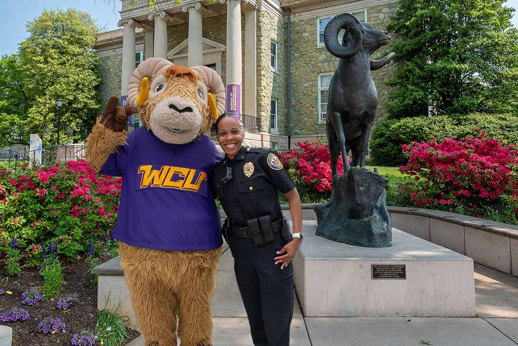 WCU officer with rammy infront of ram statue