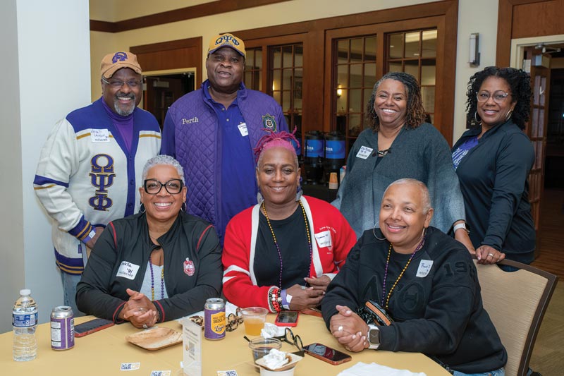 group of wcu family weekend visitors smiling around a table