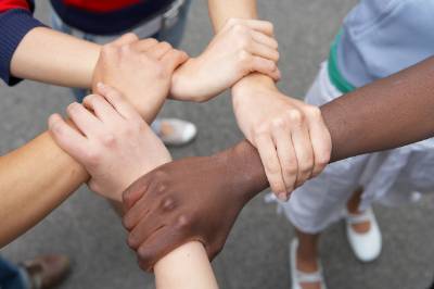 Groupdof student with handsand arms interlocked